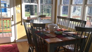 A dining area with a wooden table, chairs, and a chandelier.
