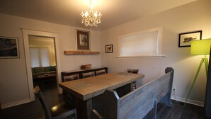 A dining area with a wooden table and chairs, a chandelier, and a window with blinds. - ♥ Maison Doucet Property | New Standard Rental | Niagara Falls ♥ (Niagara Falls)