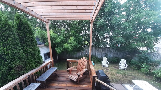 A wooden deck with a pergola, a grill, and two Adirondack chairs. - ♥ Maison Doucet Property | New Standard Rental | Niagara Falls ♥ (Niagara Falls)