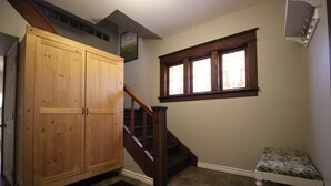 A hallway with a wooden wardrobe, a staircase, a window with stained glass, and a small bench. - ♥ Maison Doucet Property | New Standard Rental | Niagara Falls ♥ (Niagara Falls)