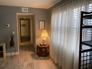 Enter a serene space with a cozy table and chair, a framed picture, and a comfortable bed.