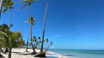Na praia, espreguiçadeiras, toalhas de praia