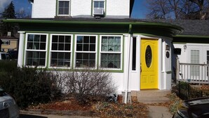 A white building with a green roof and a yellow door. -  LOVELY 1 Bedroom Apartment in the Heart of Golden (Golden)