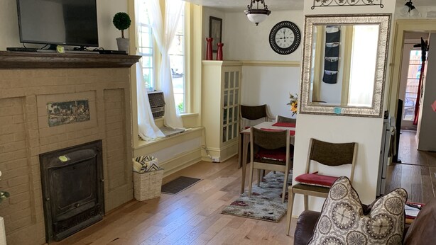 A cozy living room with a fireplace, a sofa, a wooden coffee table, and a television. -  LOVELY 1 Bedroom Apartment in the Heart of Golden (Golden)