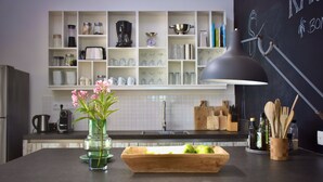 A kitchen with a wooden countertop, a vase with flowers, a cutting board with apples, and a chalkboard with drawings. -  Kas Kris, a luxury and private villa with its own pool (Kralendijk)