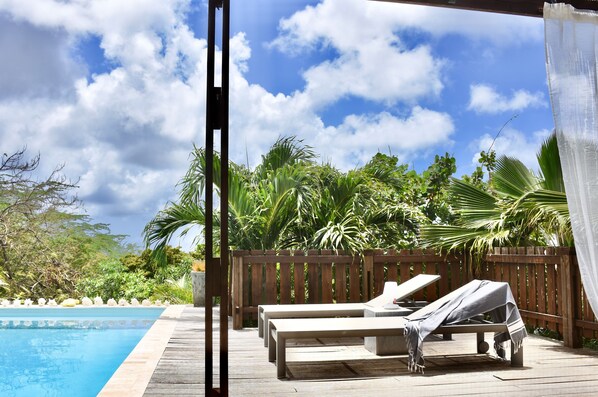 A wooden deck with lounge chairs and a pool. - Kas Kris, a luxury and private villa with its own pool (Kralendijk)