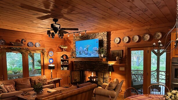 A cozy cabin interior with a fireplace, a television, and a dining area. - Beautiful Log Cabin with river access to The Watagua. Newly  added Fire Pit (Banner Elk)