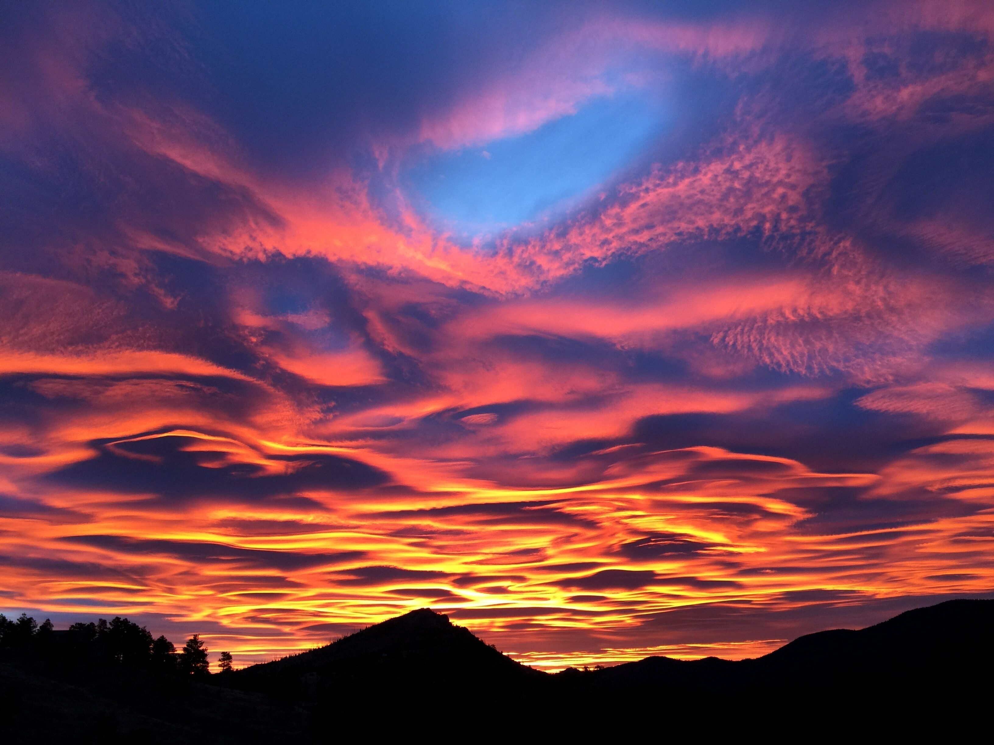 A sunset over a mountainous landscape with a clear sky.