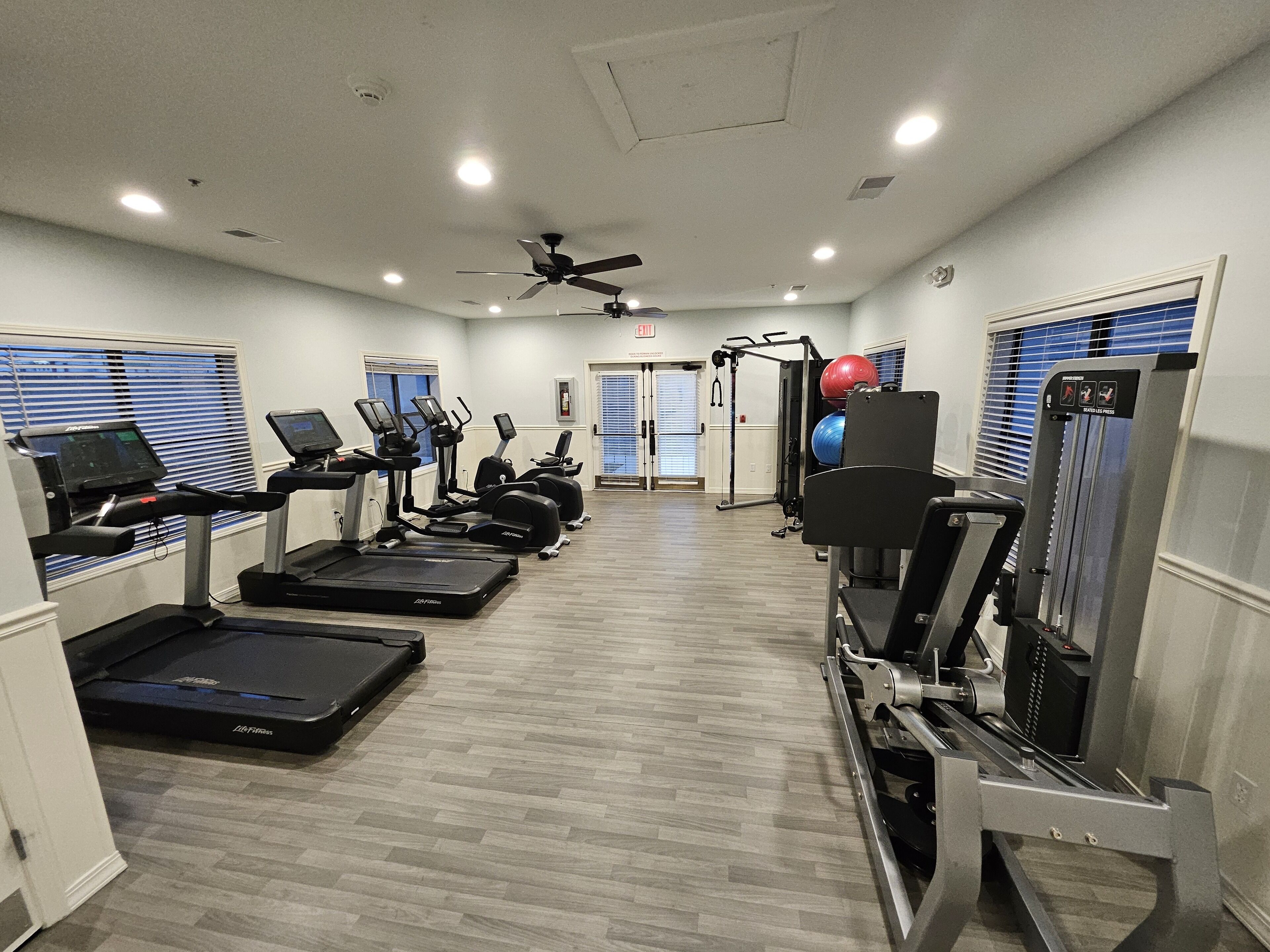 Une salle de sport équipée de tapis de course, de vélos elliptiques et de matériel de musculation.
