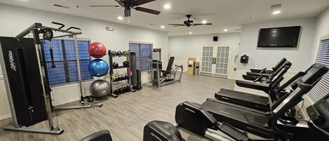 A gym with treadmills, weight machines, and exercise balls.