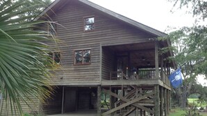 A wooden house with a covered porch and a staircase leading to a second level.