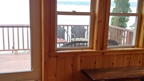 A wooden interior with a bench and a window overlooking a deck with outdoor furniture. - SHELDRAKE SPECTACULAR LAKE VIEW (Ovid)