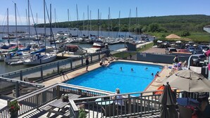 A marina with boats docked, a swimming pool, and a deck area with tables and chairs. - Bayfield- Charming Condo, Jumping Off Point to Apostles (Bayfield)