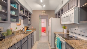 A kitchen with granite countertops, a built-in oven, a microwave, and a refrigerator. - The Beach Retreat, 3 Beds, Walk to Beach, Shops & Pier, Beach Items Included (St Augustine Beach)