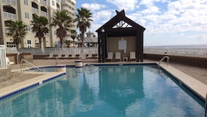 A swimming pool with lounge chairs, a gazebo, and a building with balconies. - ⛱ 803 /ON the BEACH! 🏖 (Orange Beach)