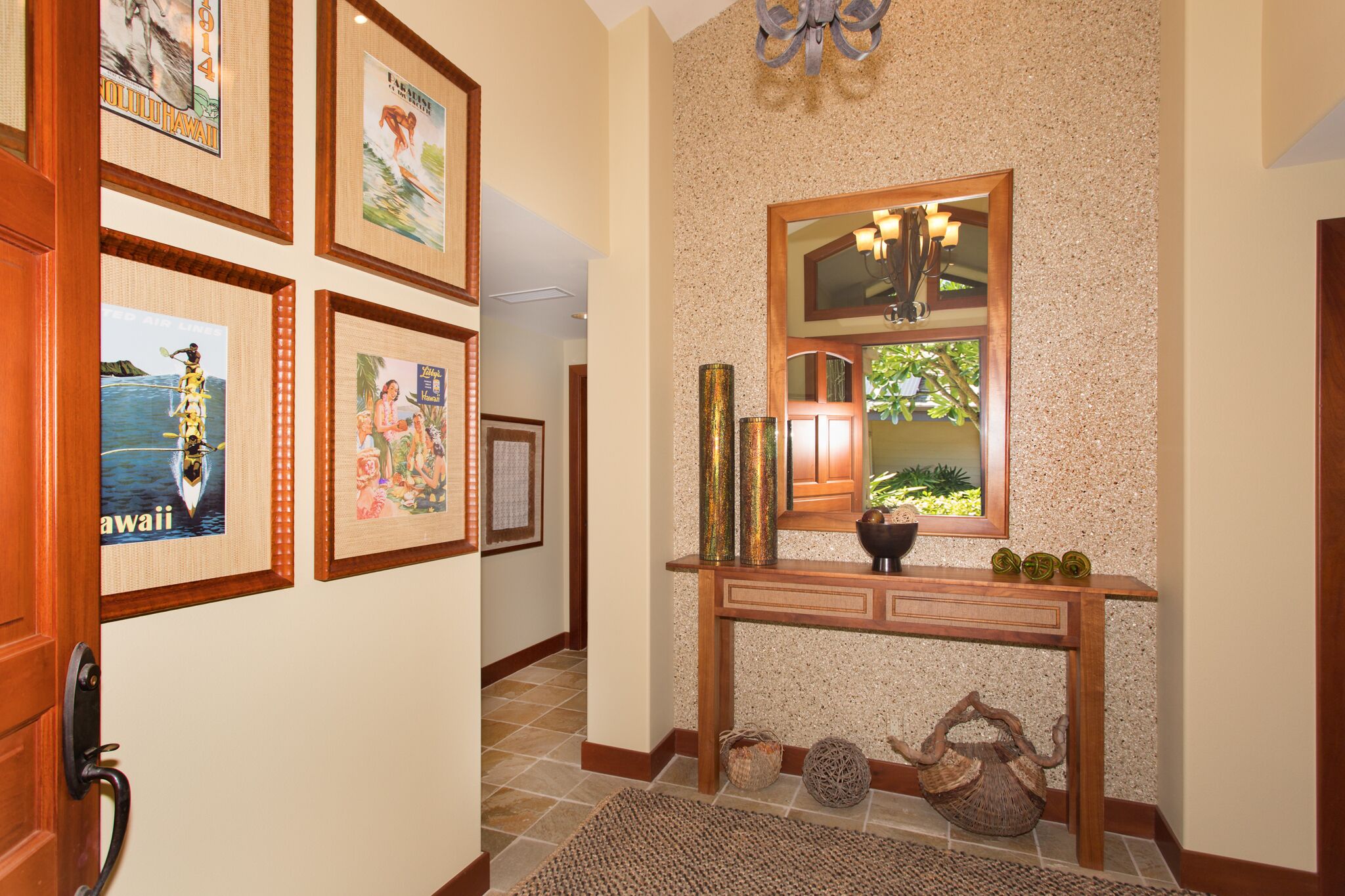 A hallway with framed pictures, a wooden console table, and a mirror.