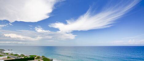 A pool with a clear view of the ocean and a distant coastline.