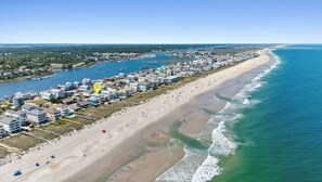 Une ville côtière dotée de propriétés en bord de mer, d’un port de plaisance et d’une plage de sable.