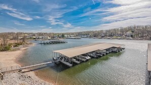 Una extensa propiedad frente al mar con un muelle techado y varias embarcaciones.