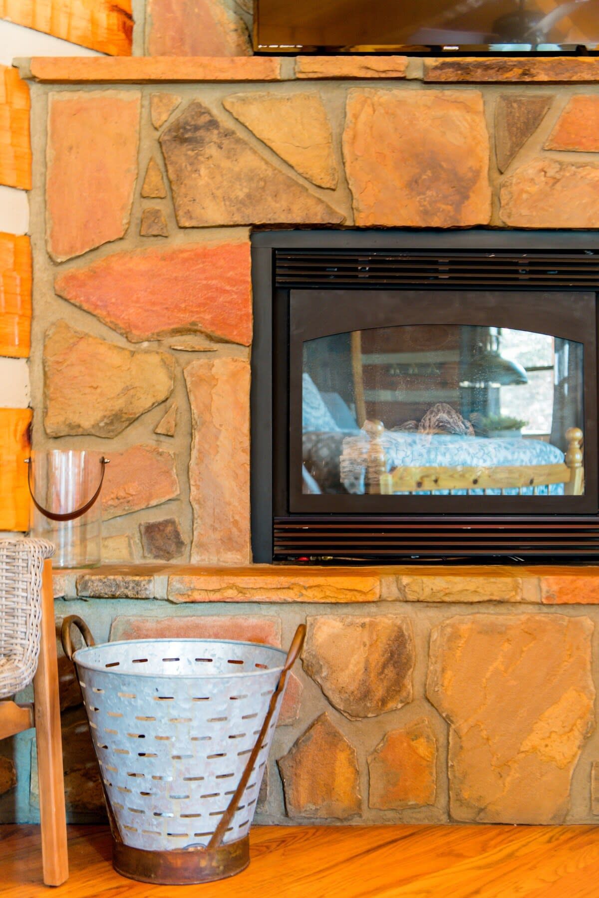 A stone fireplace with a black TV mounted above it.