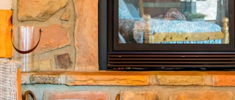 Una chimenea de piedra con un televisor negro montado encima.