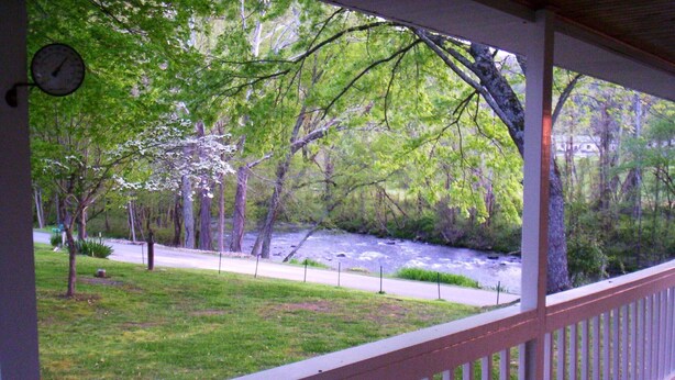 Une véranda avec vue sur une rivière et des arbres.