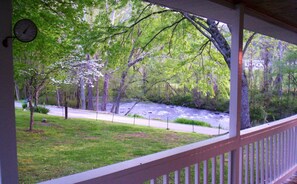 Een veranda met uitzicht op een rivier en bomen.