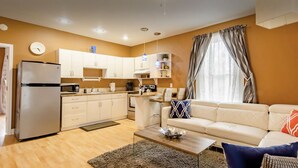A compact living space with a kitchenette, a sofa, a coffee table, and a dining area. - 1880 Victorian In Heart Of Downtown  (St. Augustine)