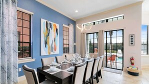 A dining area with a table set for six, large windows, and a view of the outdoors. - Spacious, game room, golf view, private pool & BBQ (Kissimmee)