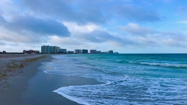 A beach with a row of high-rise buildings in the background.