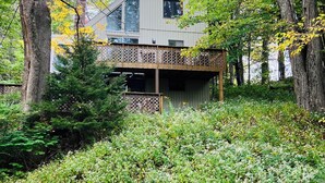 Ein modernes Gebäude mit Balkon, umgeben von Bäumen und viel Grün.