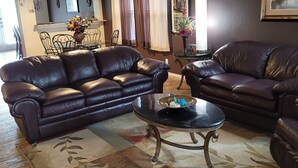 A living room with two leather sofas, a coffee table, and a patterned rug. - Air & Space Force Basic Training Grads/Ex-Large home mins from Lackland AFB/Golf (San Antonio)