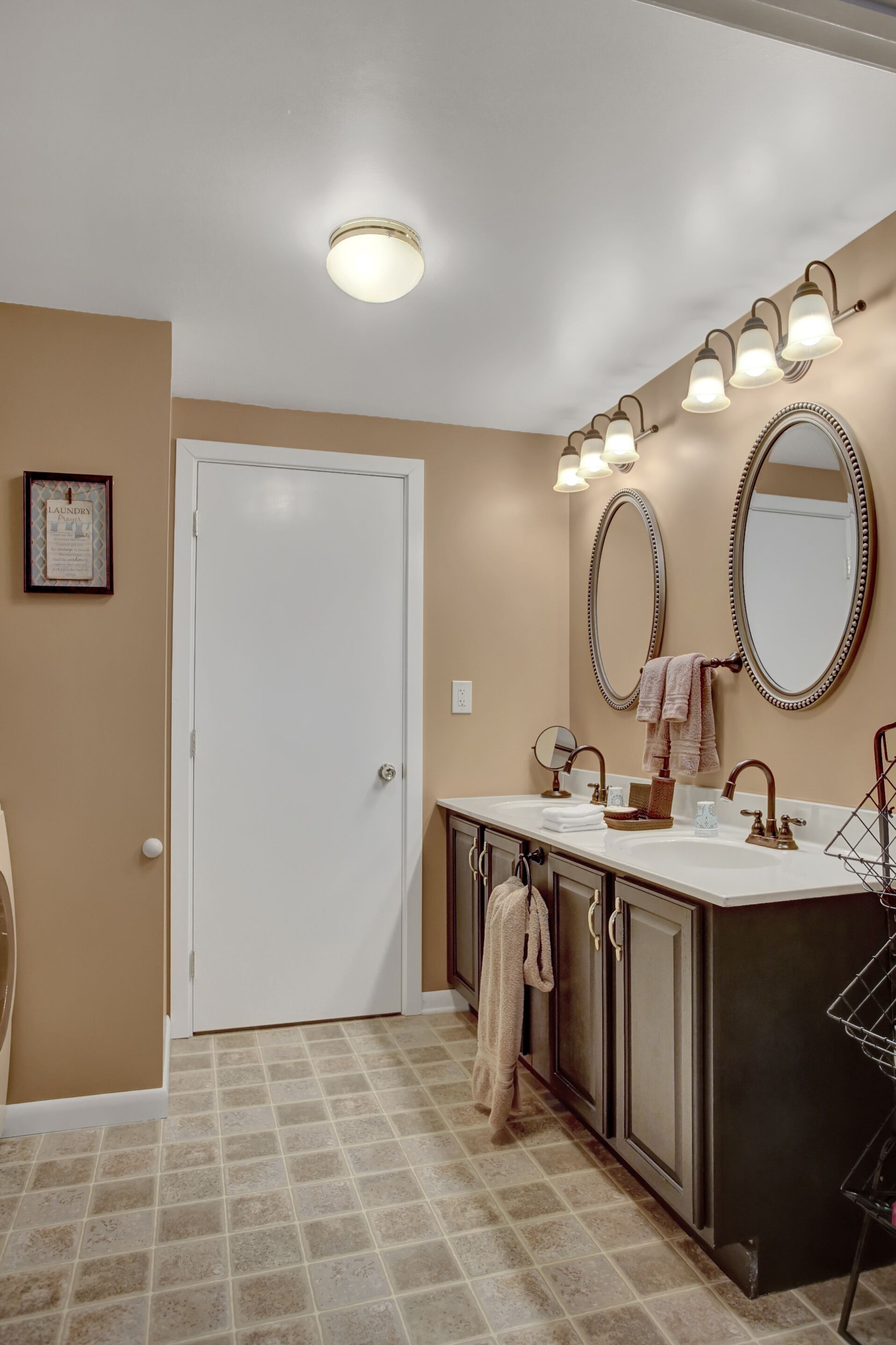 A bathroom with two sinks, a large mirror, and a towel rack.