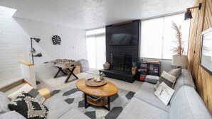 A modern living room with a sofa, coffee table, and a fireplace.