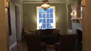 A room with a chandelier, a fireplace, and a large window. - Stunning Mediterranean Monument Avenue flat in the heart of RVA's Fan District (Richmond)
