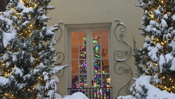 A building with a snow-covered entrance, a balcony with a railing, and a window with decorative lights. - Stunning Mediterranean Monument Avenue flat in the heart of RVA's Fan District (Richmond)
