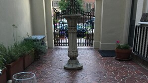 A table with a cheese board, crackers, a black berry, and wine glasses on a tiled patio. - Stunning Mediterranean Monument Avenue flat in the heart of RVA's Fan District (Richmond)