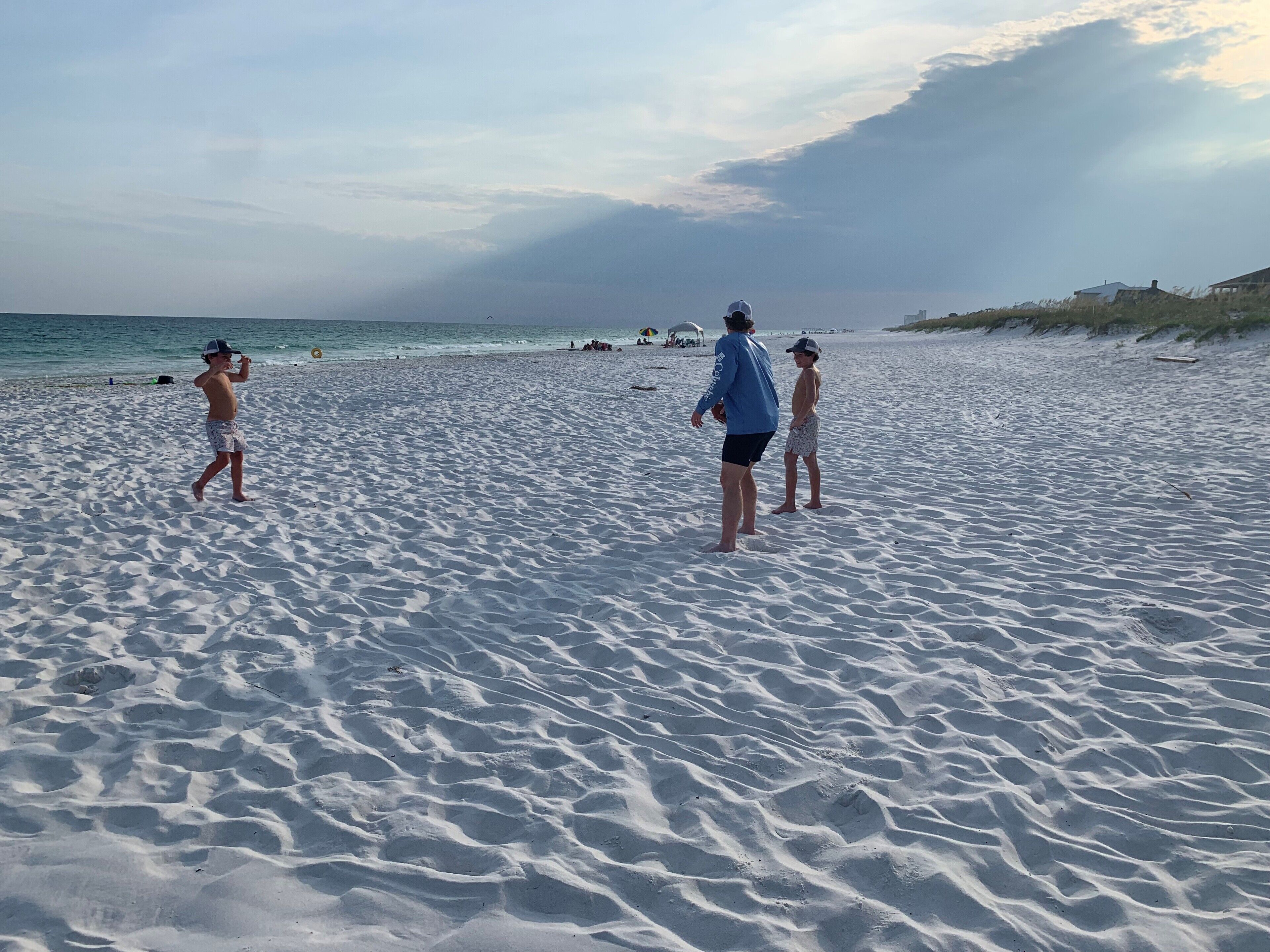 Ein Sandstrand mit Menschen, die laufen und stehen.