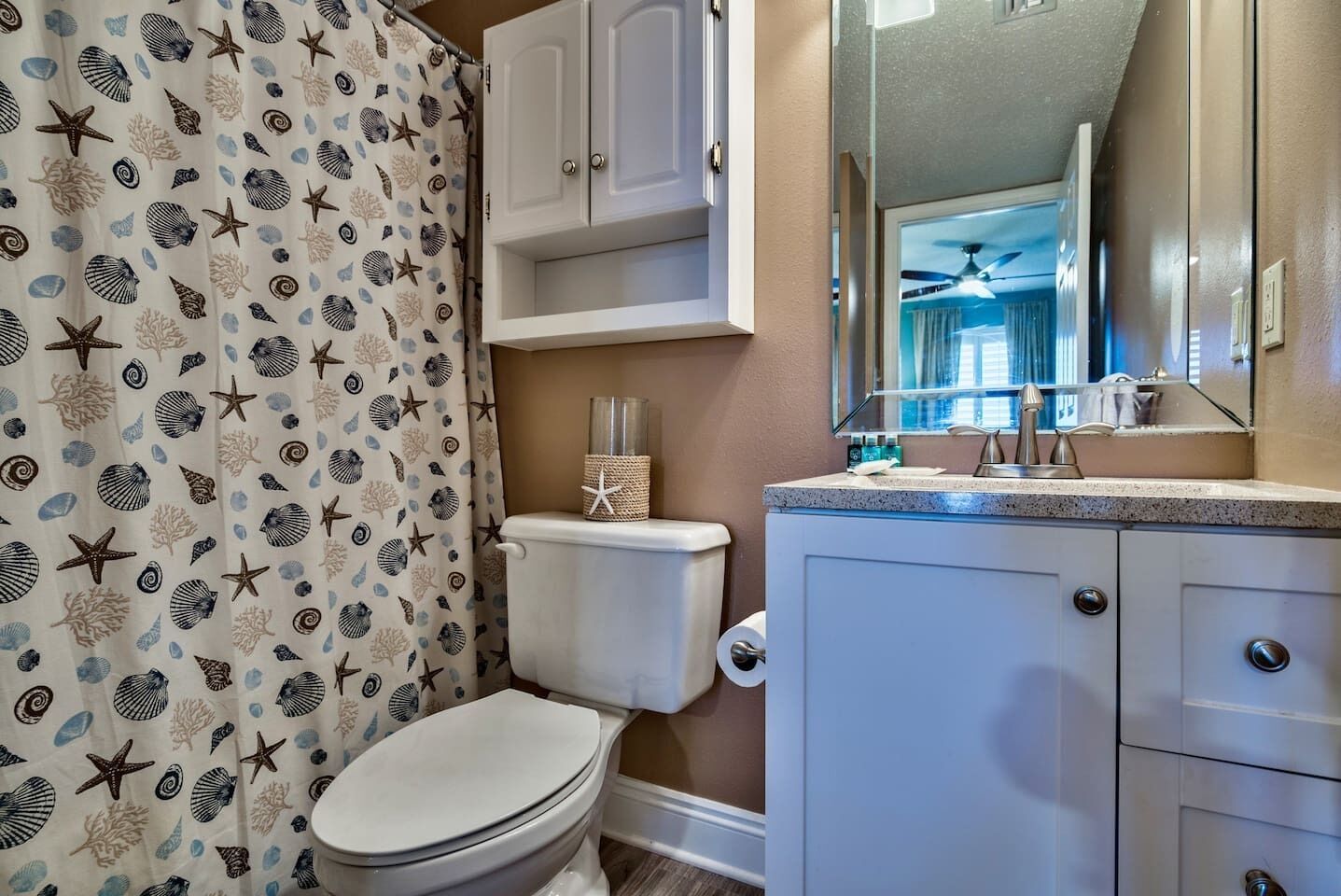 A bathroom with a toilet, a sink, and a cabinet.