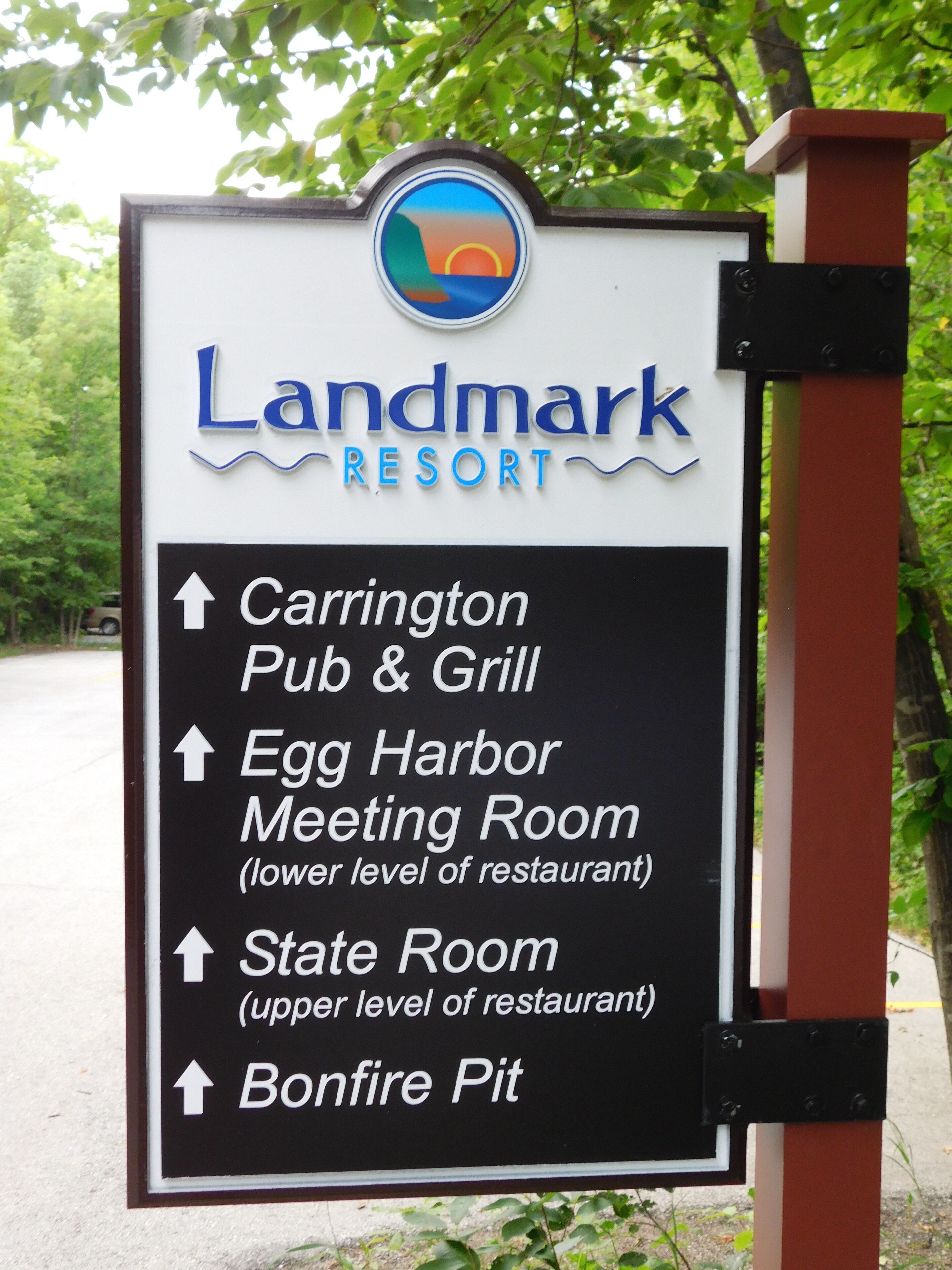 Schild für Landmark Resort mit Pfeilen zu Carrington Pub & Grill, Egg Harbor Meeting Room, State Room und Bonfire Pit.