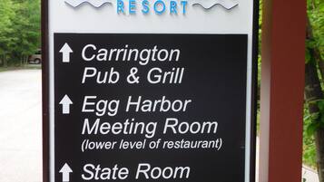 Schild für Landmark Resort mit Pfeilen zu Carrington Pub & Grill, Egg Harbor Meeting Room, State Room und Bonfire Pit.