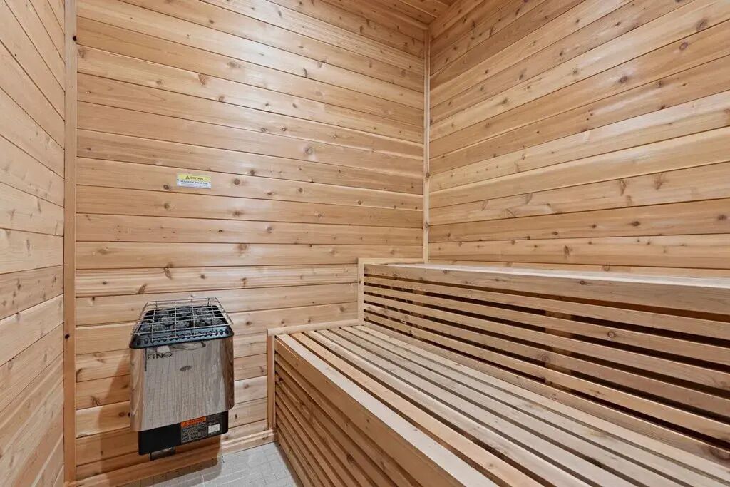 Una sauna de madera con bancos y un calentador.
