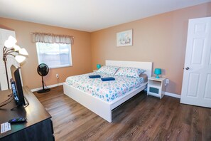 A bedroom with a bed, bedside tables, a desk with a lamp, a fan, and a window with blinds. - 3/2 Home Heated Pool / close to Beautiful Anna Maria Beaches / close to IMG (Bradenton)