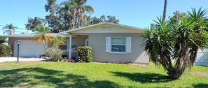 A single-story house with a garage, a small porch, and a well-maintained lawn. - 3/2 Home Heated Pool / close to Beautiful Anna Maria Beaches / close to IMG (Bradenton)