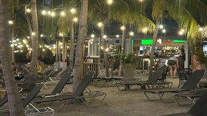 A beachside bar with lounge chairs and palm trees, featuring string lights and a visible bar area. - PREMIER HOST Private 3 bdrm, 1600 sq ft Fully Air-Conditioned villa in Blue Bay (Sint Michiel)
