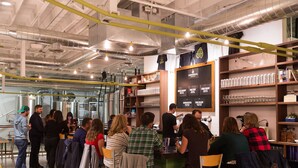A spacious indoor area with high ceilings, exposed ductwork, and a variety of seating arrangements. - Charming Studio in Heart of City Park--Minutes to downtown!! MANY AMENITIES!! (Denver)