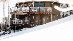 A two-story building with a balcony on the upper floor, surrounded by snow.