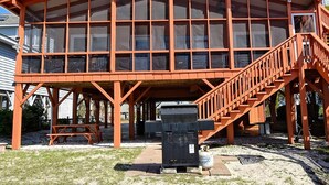 Een ruime, open paviljoen met houten constructie en meerdere ramen.