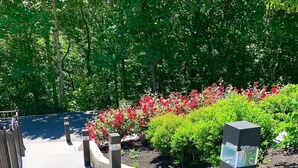 A set of outdoor stairs leading up to a building, surrounded by greenery and flowers. - 3 BR/3BATH Retreat 1.5 miles from Attraction/Resort Pool/Pool Table/Arcade (Pigeon Forge)