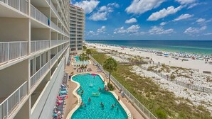 Ein Hochhotel mit Swimmingpool, Blick auf den Strand und mehreren Balkonen.